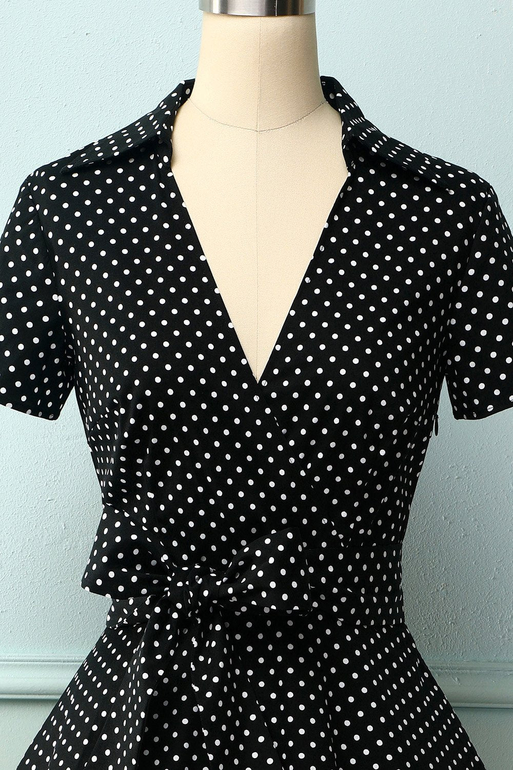 Robe noire à petits pois blancs et décolleté en V