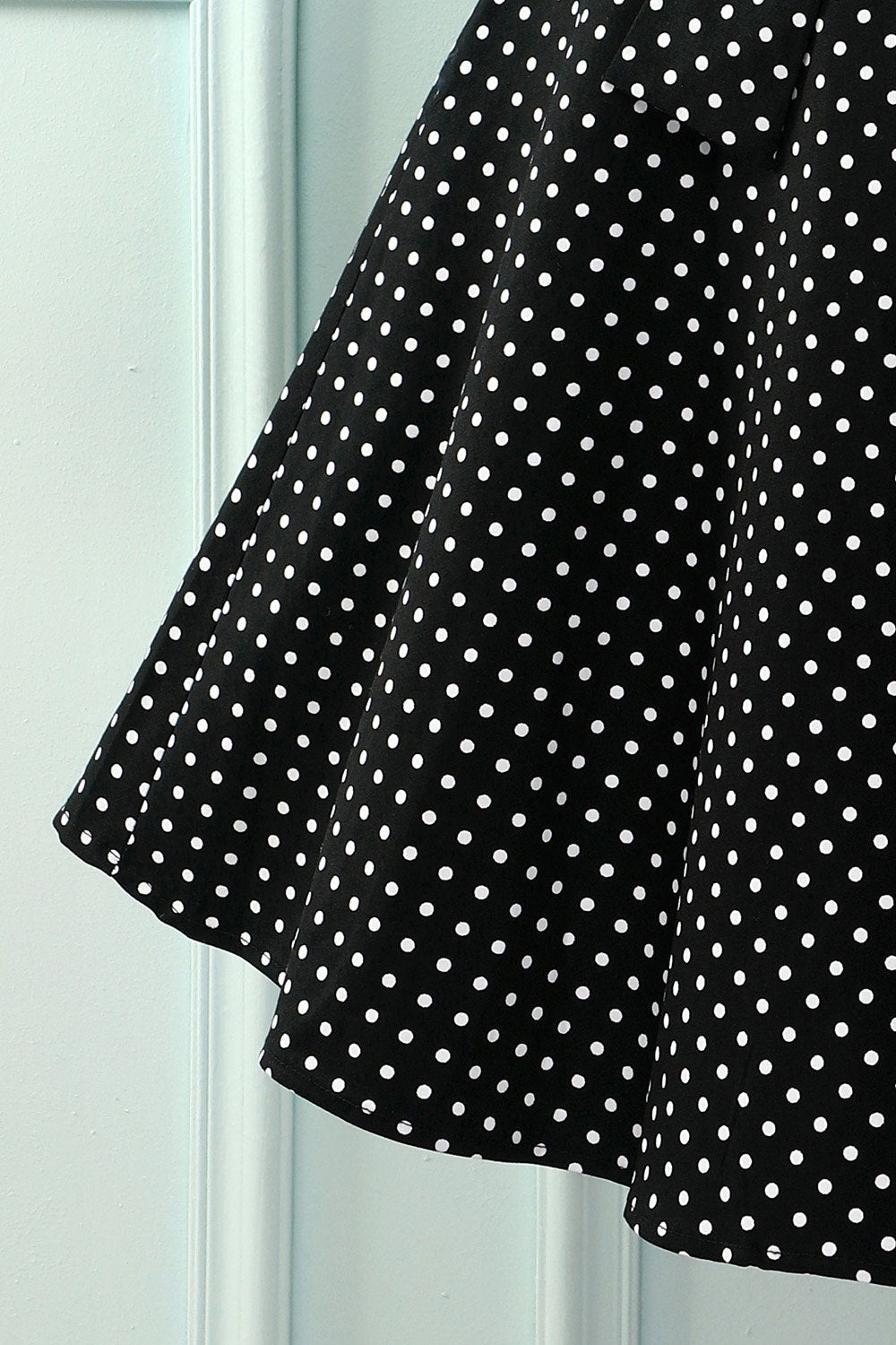 Robe noire à petits pois blancs et décolleté en V