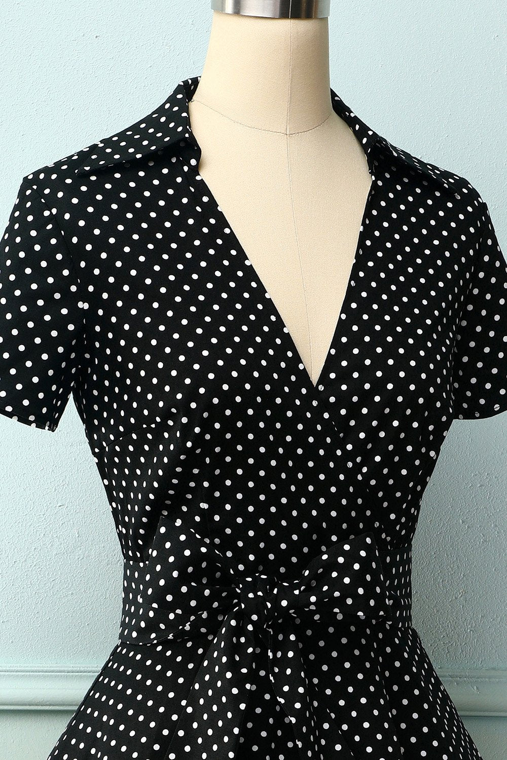 Robe noire à petits pois blancs et décolleté en V