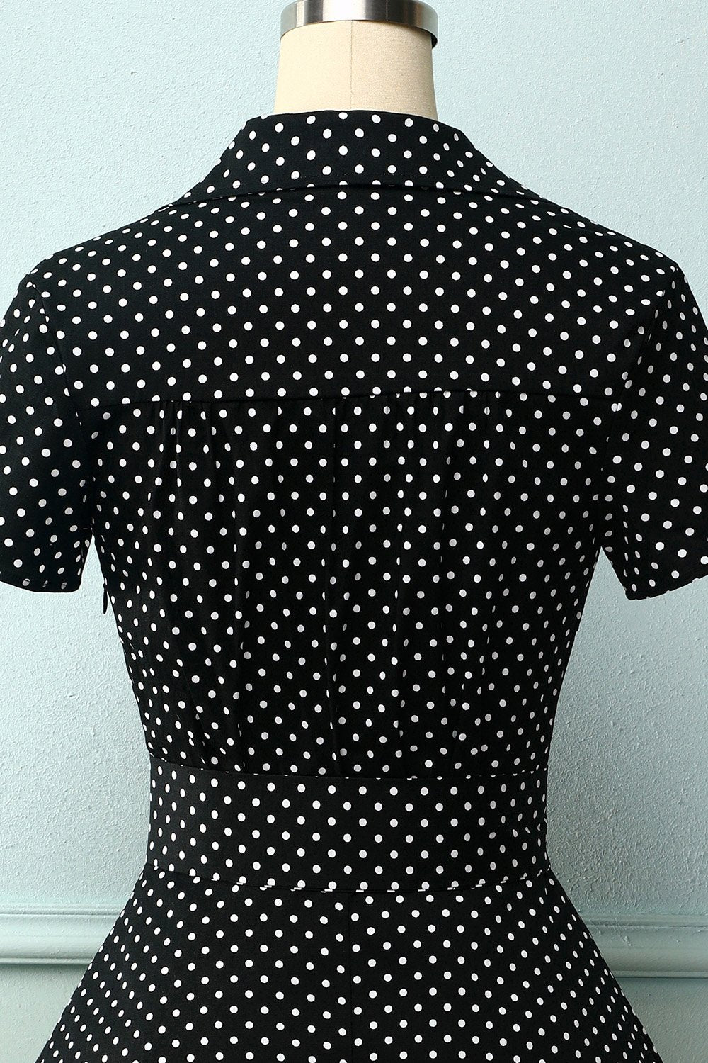 Robe noire à petits pois blancs et décolleté en V