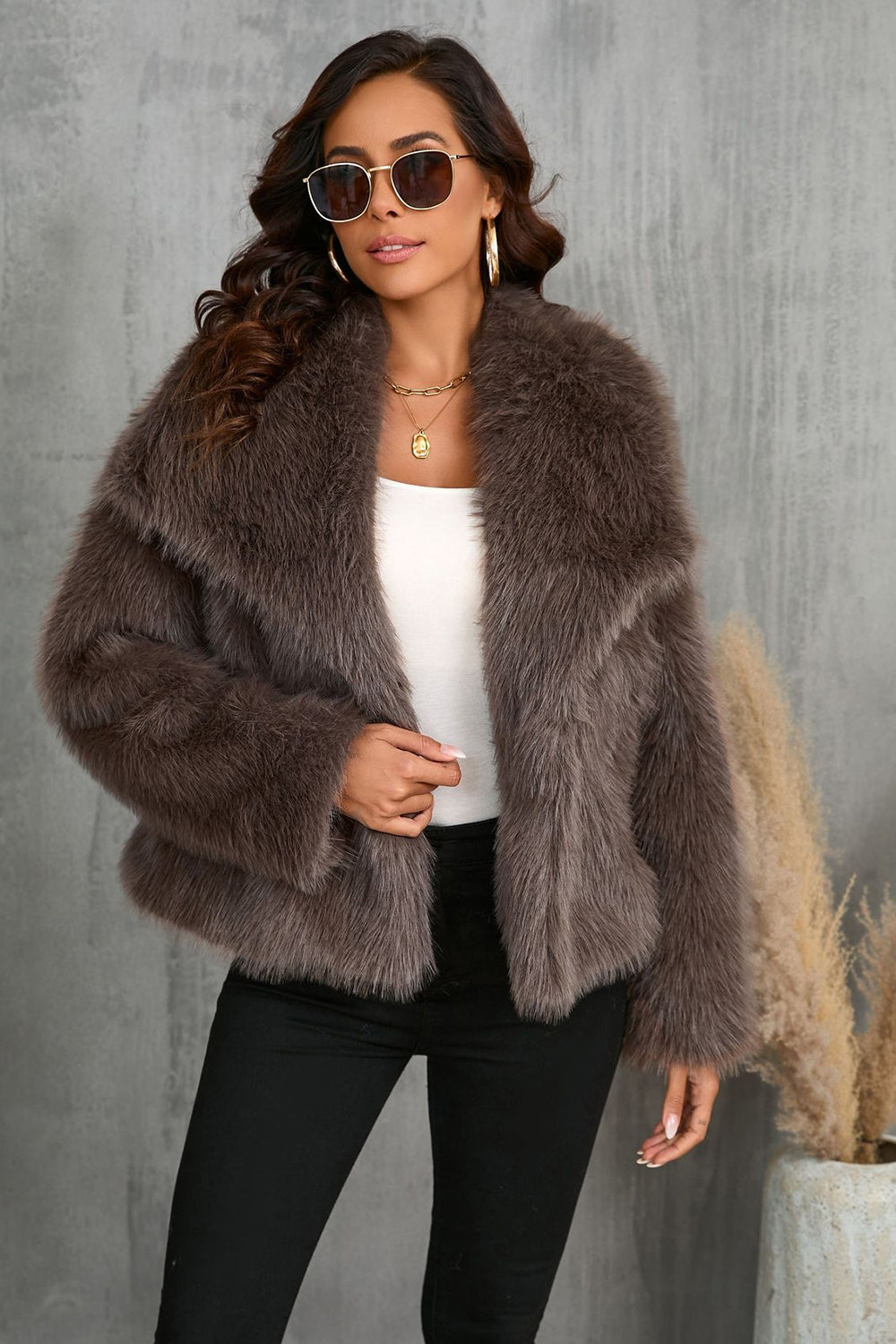 Manteau d'hiver en fausse fourrure noire duveteuse à revers.