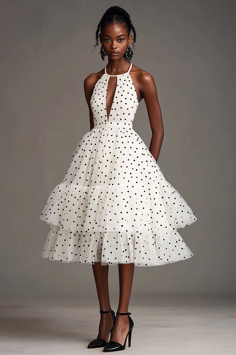 Robe blanche à pois noirs, coupe trapèze, dos nu et découpes