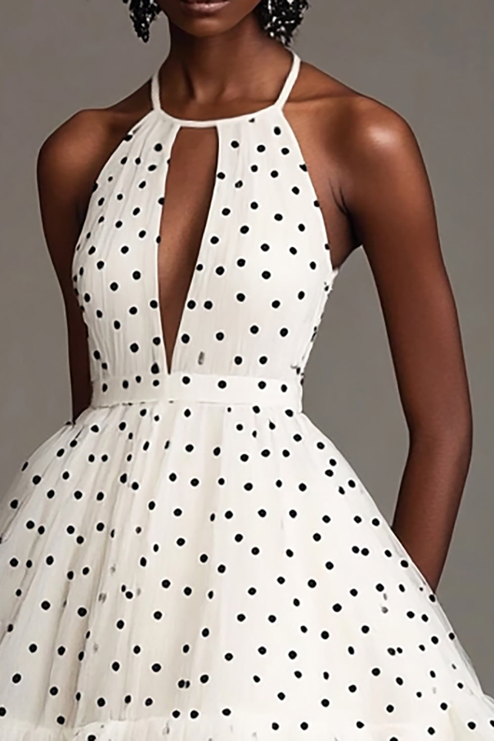 Robe blanche à pois noirs, coupe trapèze, dos nu et découpes