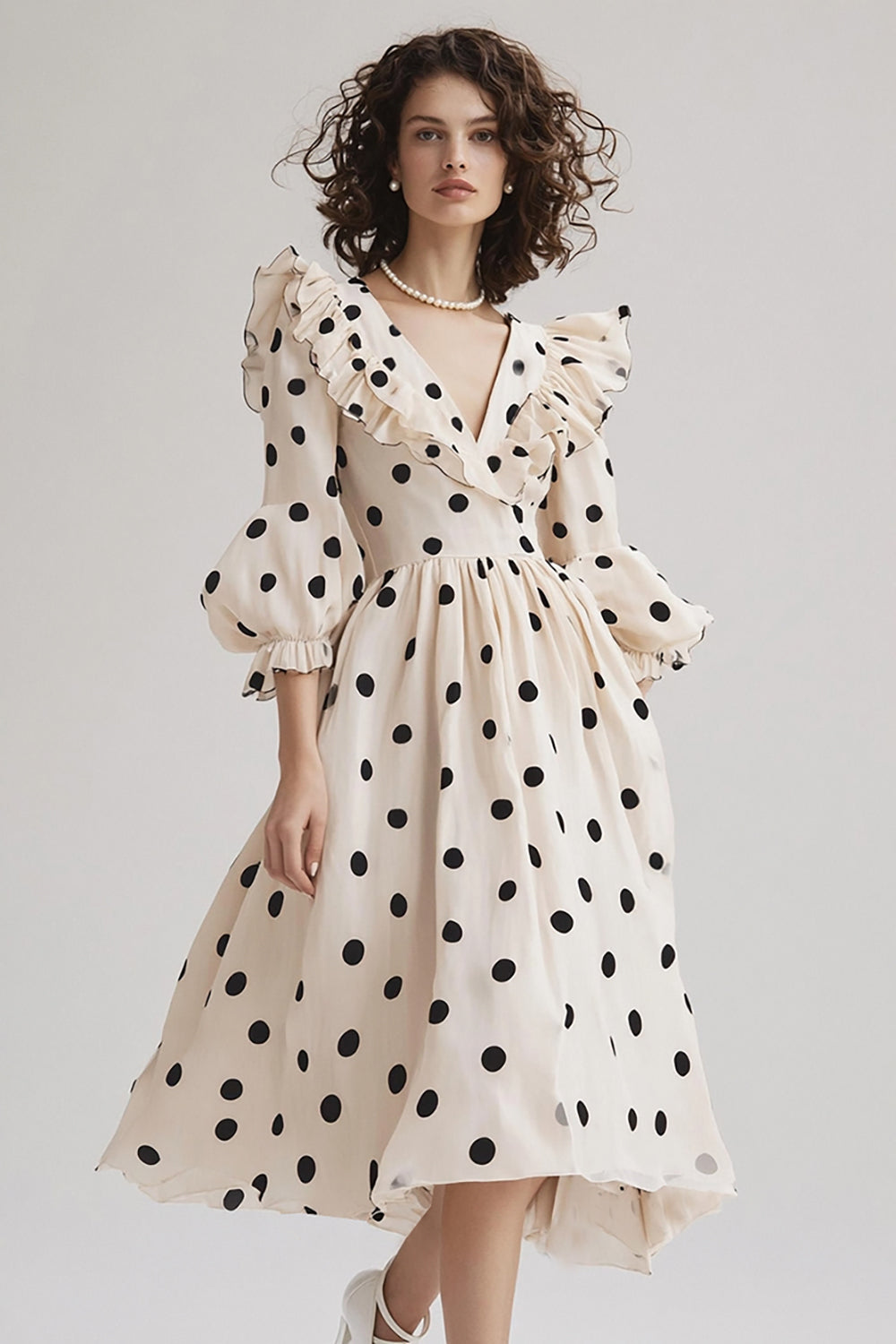 Robe en ivoire coupe A, col en V, à pois noirs volantés, avec manches bouffantes