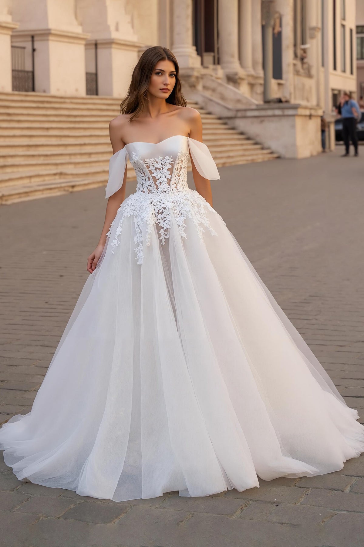 Robe de mariée ivoire avec des appliques, décolleté épaules dénudées, coupe trapèze et traîne.