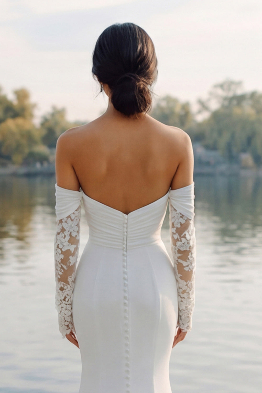 Robe de mariée sirène en satin ivoire avec manches, col Bardot et traîne balayage