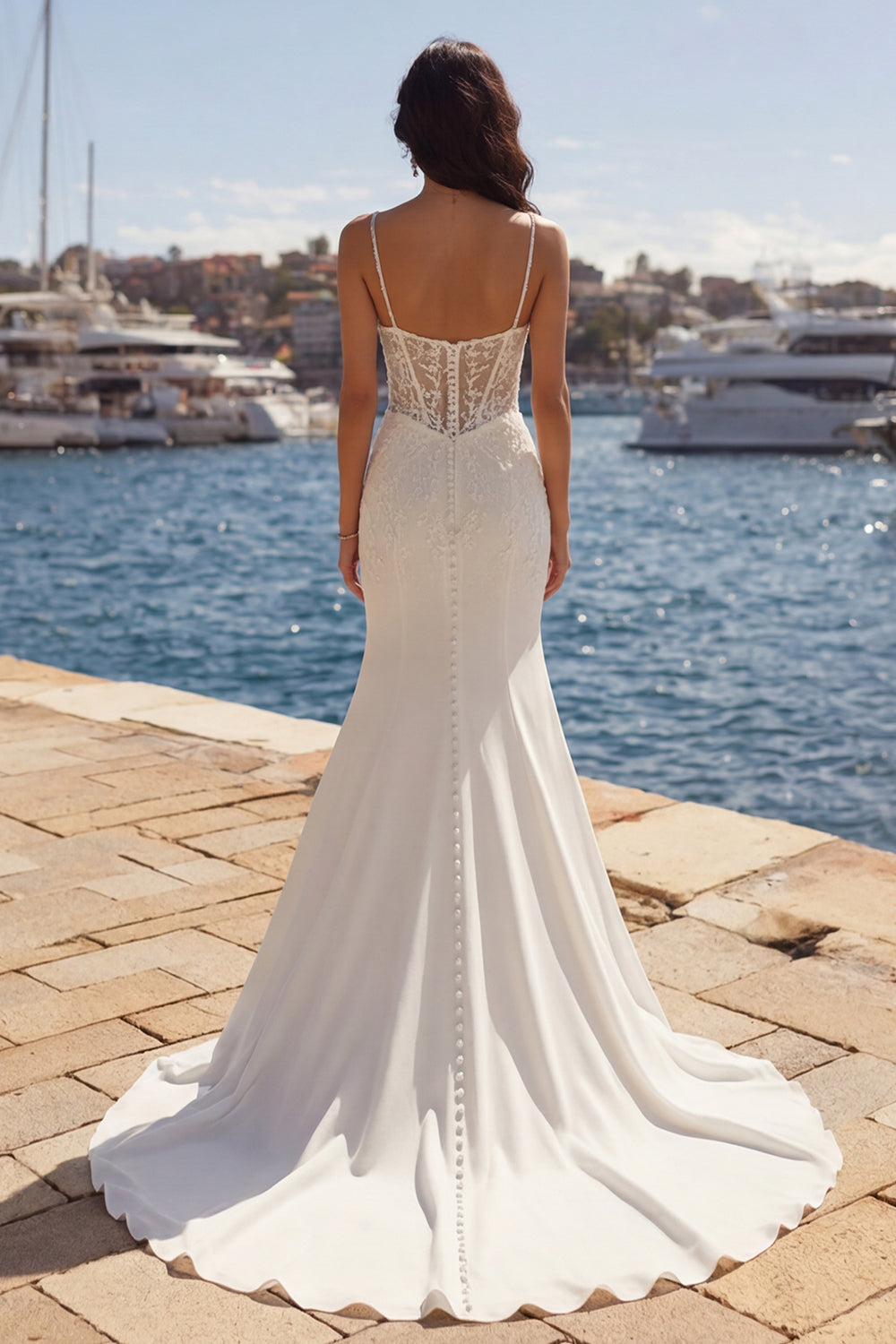 Vestido de novia color marfil corte sirena con apliques y cola capilla