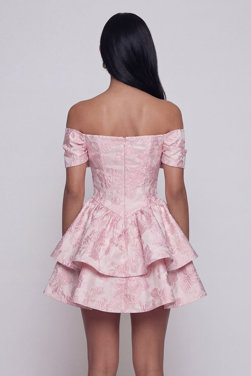 Robe de cocktail mini rose en jacquard, coupe trapèze, épaules dénudées, à volants et nœud