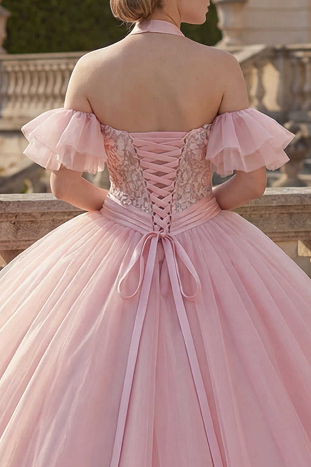 Vestido de quinceañera rosa con cuello halter, apliques y mangas con volantes