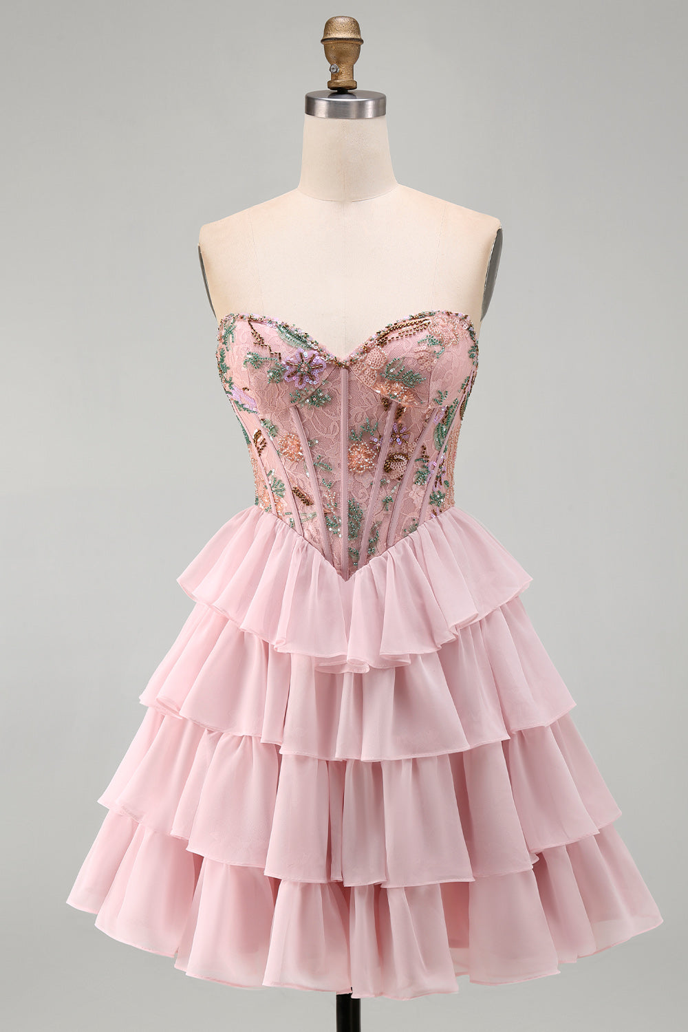 Robe de bal rose avec corsage bustier, taille basque, volants étagés et sequins