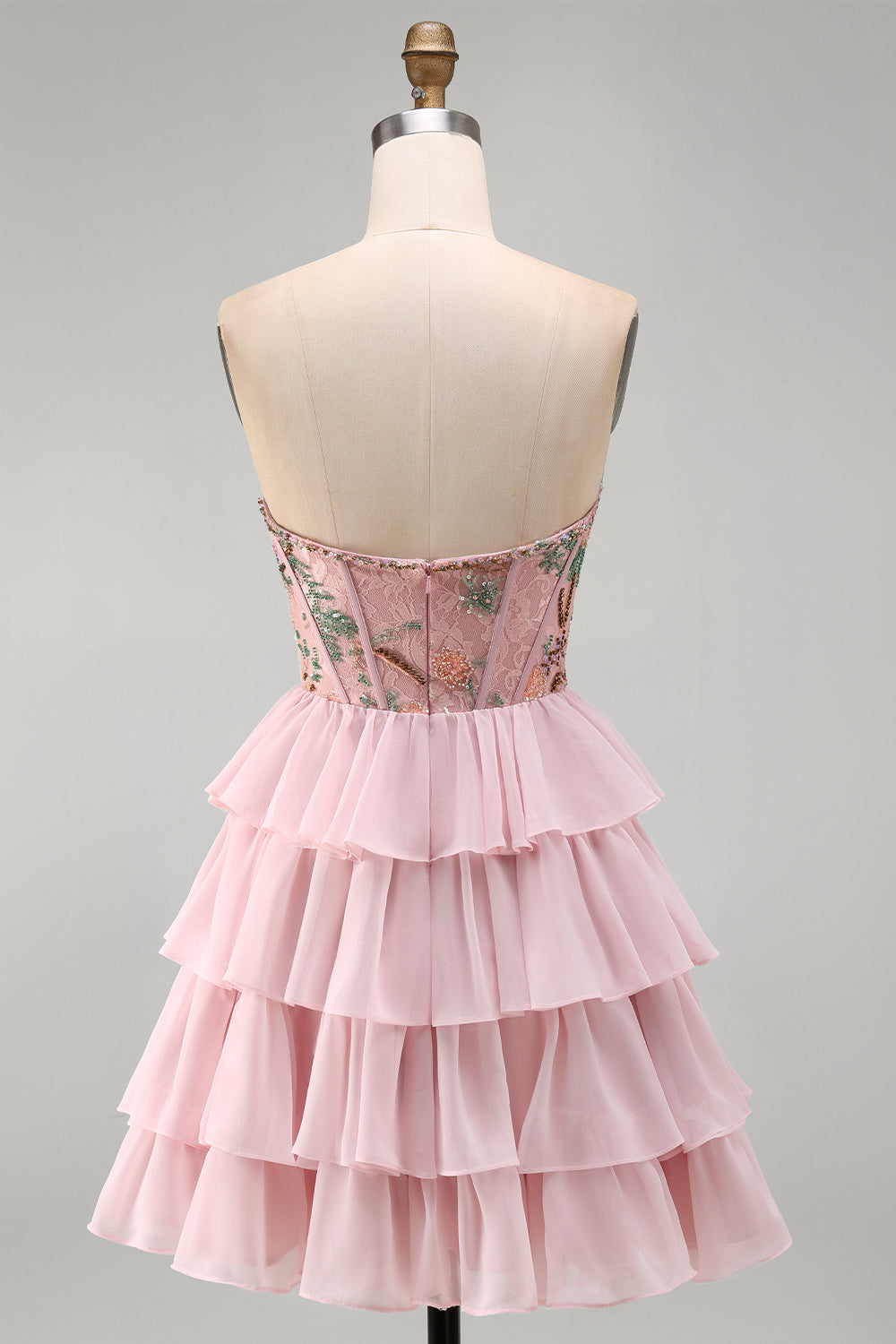 Robe de bal rose avec corsage bustier, taille basque, volants étagés et sequins