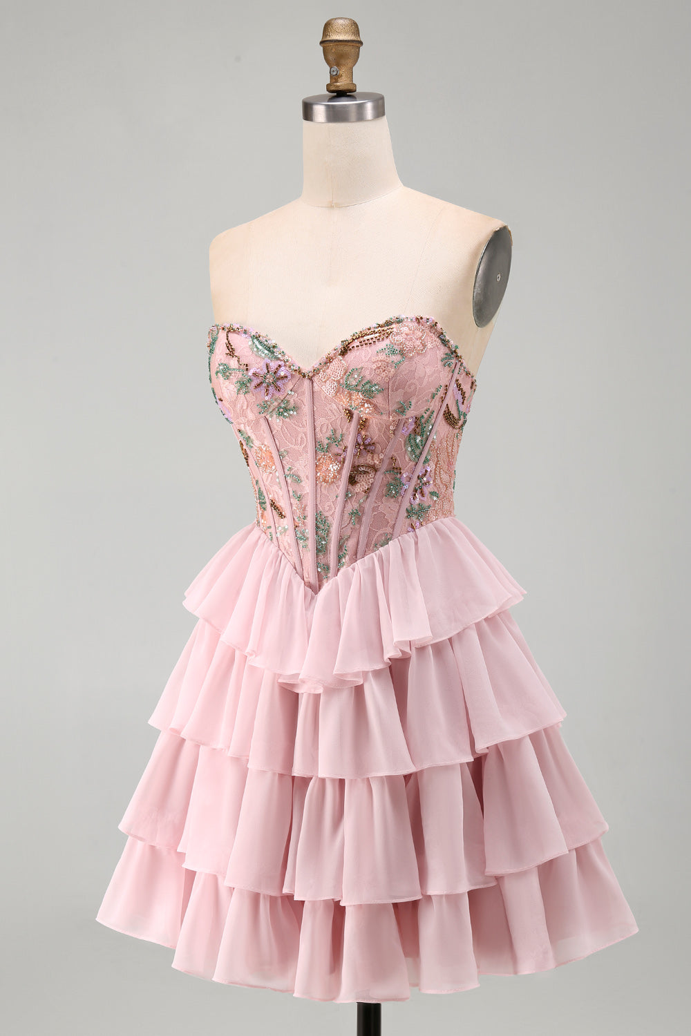 Robe de bal rose avec corsage bustier, taille basque, volants étagés et sequins