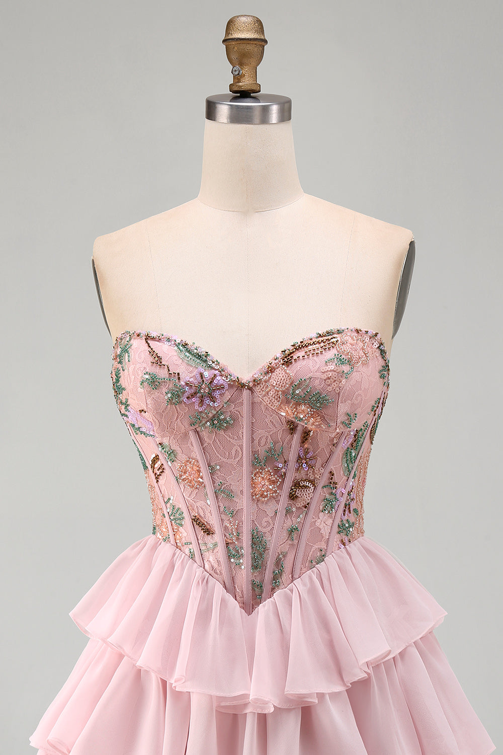 Robe de bal rose avec corsage bustier, taille basque, volants étagés et sequins