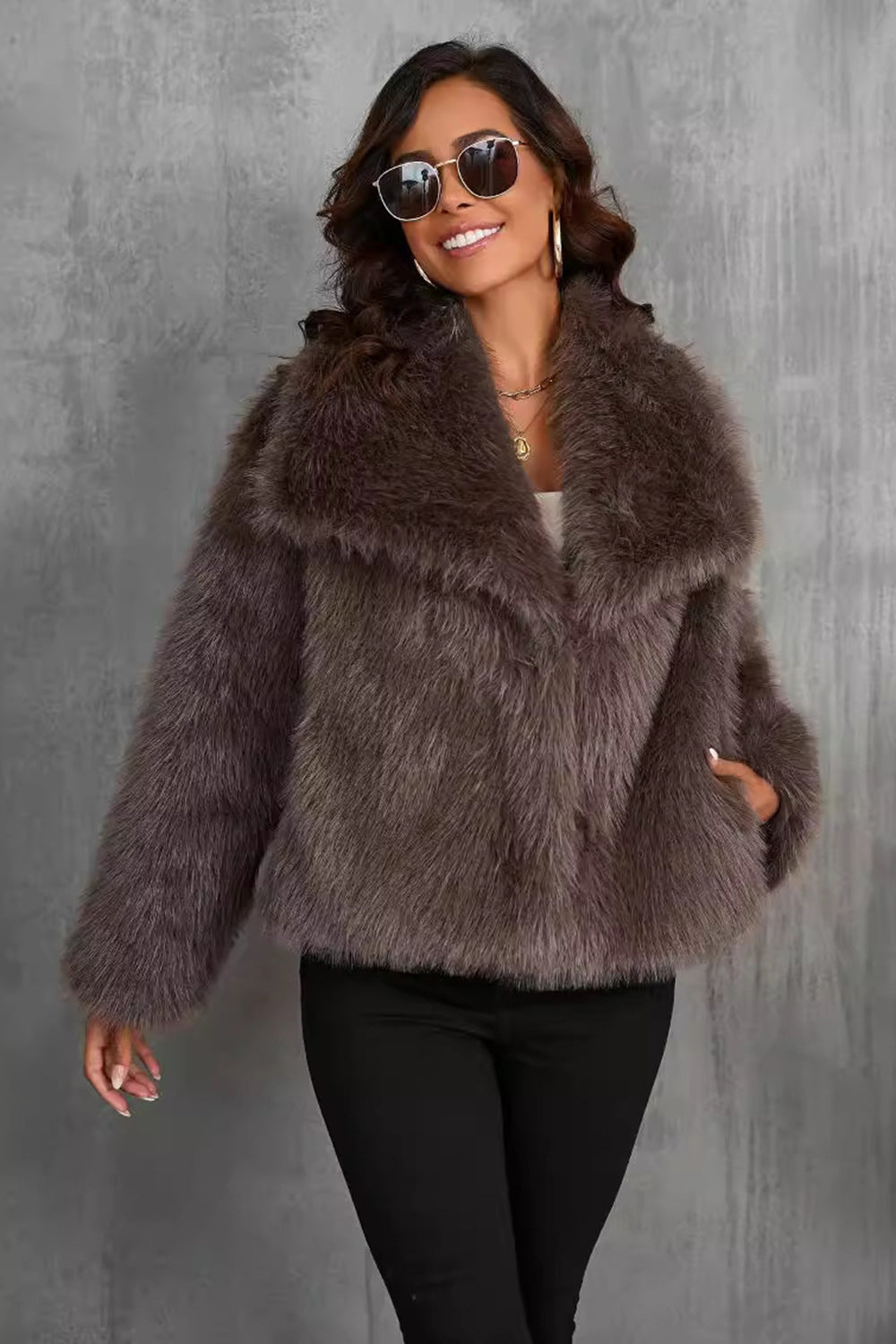 Manteau d'hiver en fausse fourrure noire duveteuse à revers.