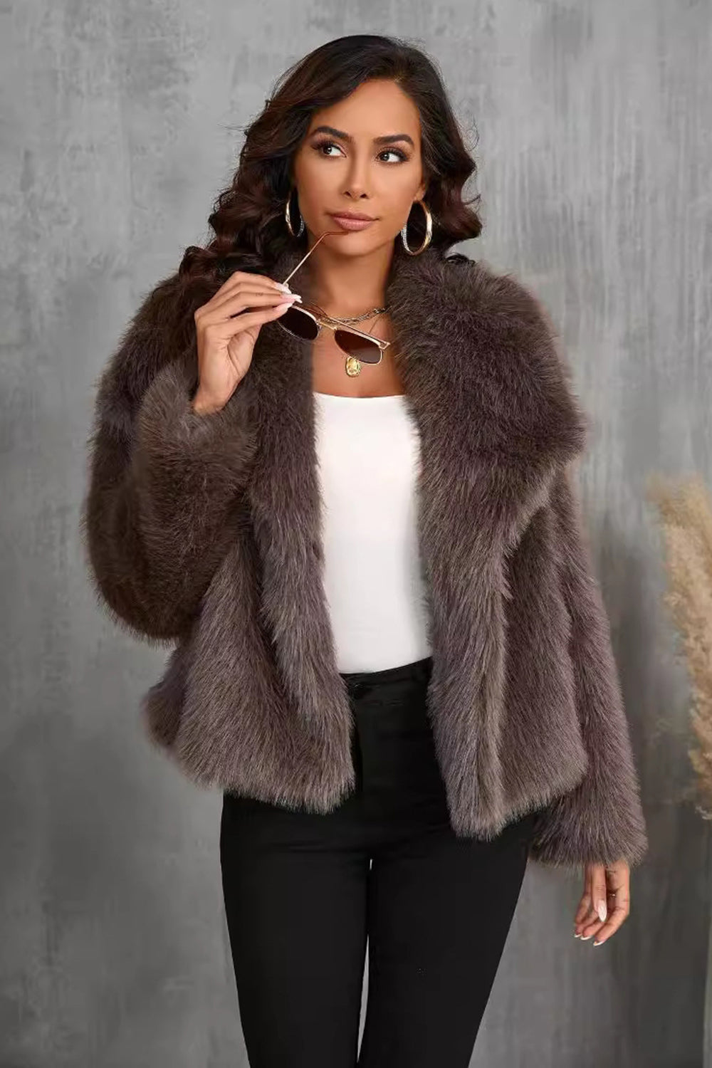 Manteau d'hiver en fausse fourrure noire duveteuse à revers.