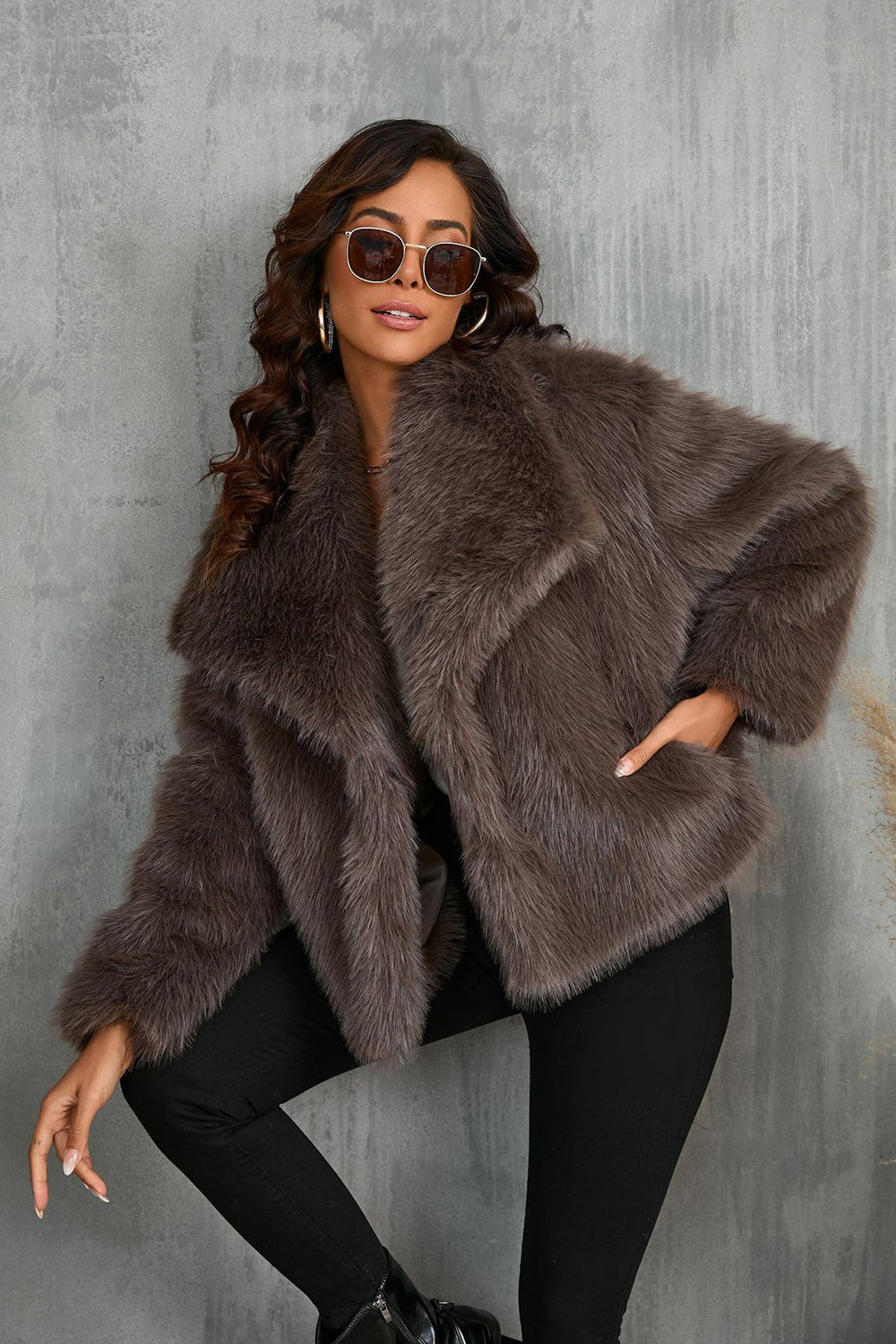 Manteau d'hiver en fausse fourrure noire duveteuse à revers.