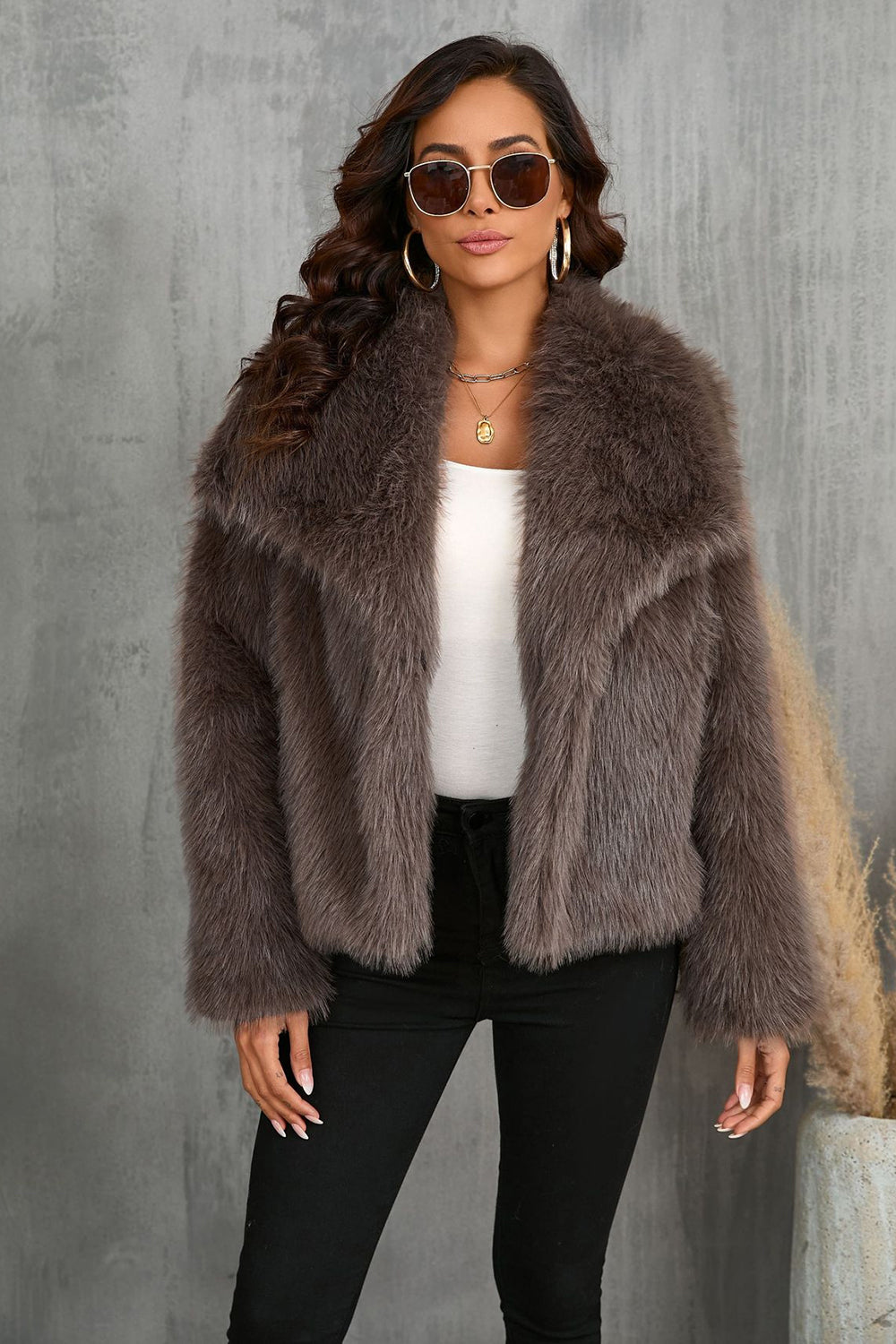 Manteau d'hiver en fausse fourrure noire duveteuse à revers.