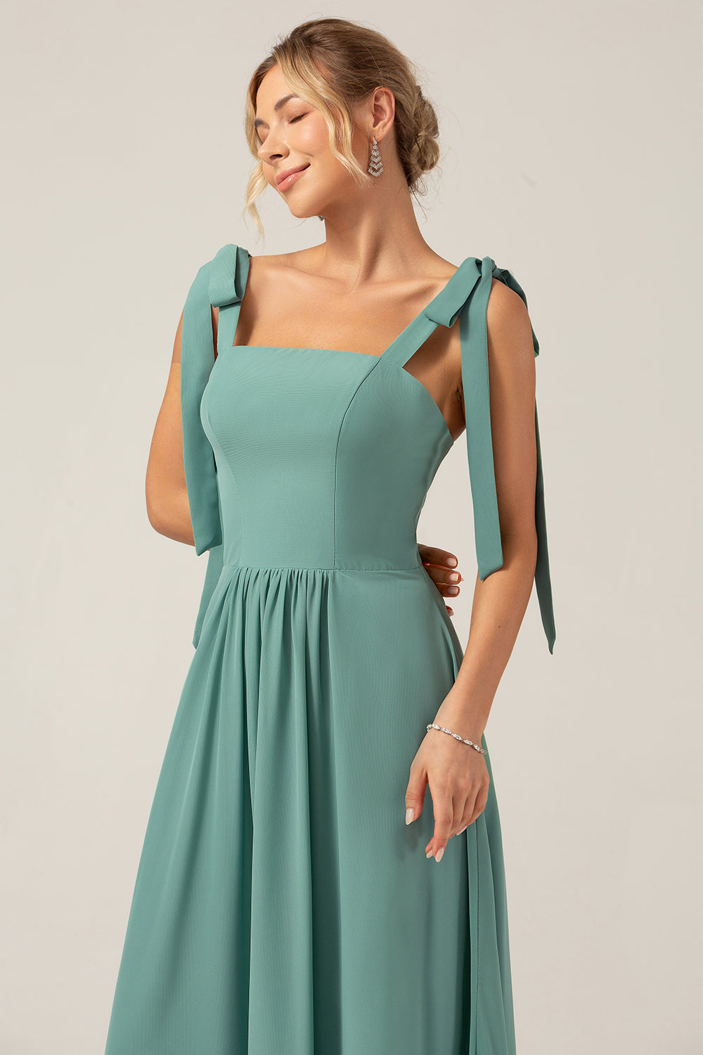 Une robe longue de demoiselle d'honneur en mousseline de soie Eucalyptus coupe A avec plissé