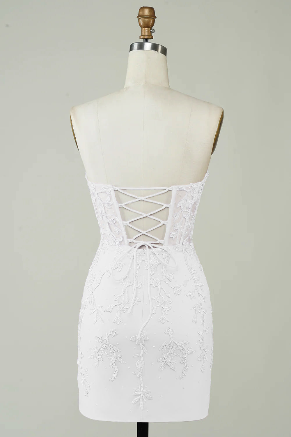 Petite robe blanche moulante à fines bretelles et appliqués