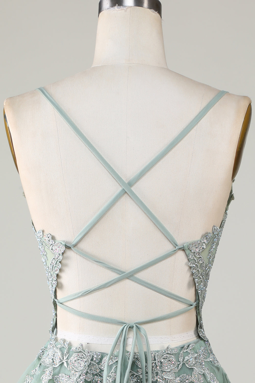 Robe de bal courte verte avec fines bretelles, coupe trapèze et appliques